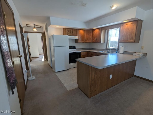 kitchen with sink, white appliances, and kitchen peninsula