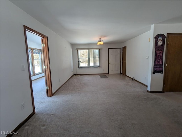 spare room featuring light carpet