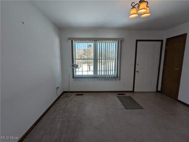 interior space with an inviting chandelier and carpet floors