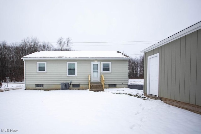 snow covered property with central AC unit