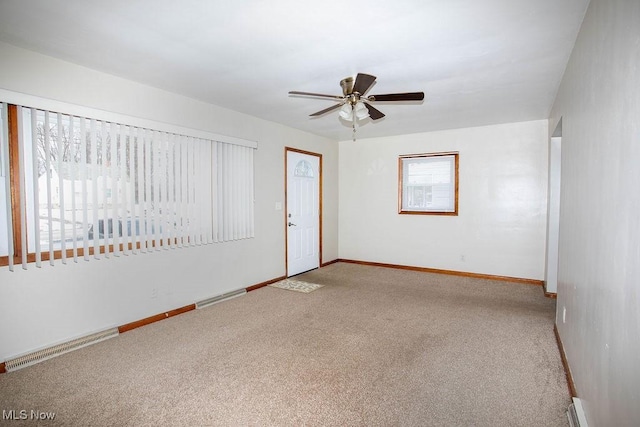 carpeted spare room featuring baseboard heating and ceiling fan