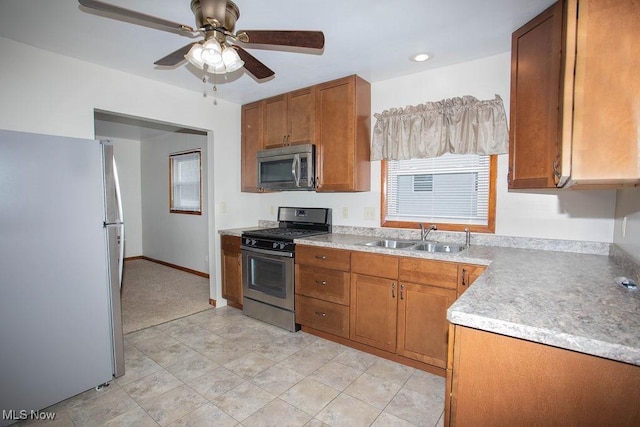 kitchen with appliances with stainless steel finishes, ceiling fan, and sink