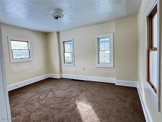 carpeted spare room with a textured ceiling