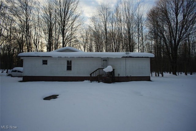 view of snow covered back of property