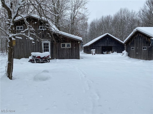 yard layered in snow featuring an outbuilding