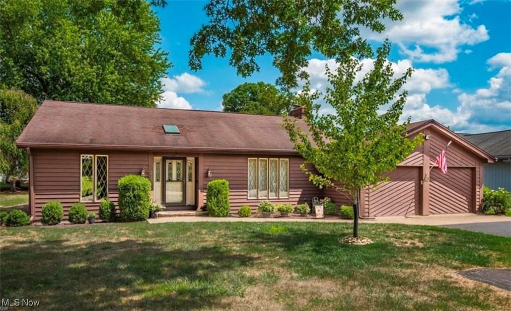 view of front of home with a front lawn and a garage