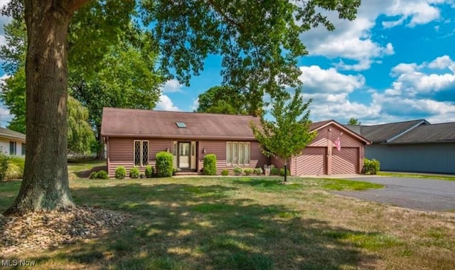 ranch-style house with a garage and a front lawn