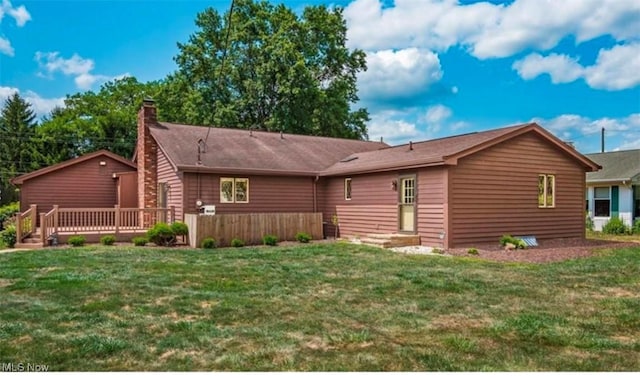 rear view of property featuring a yard and a wooden deck