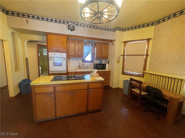 kitchen with black appliances, an inviting chandelier, sink, and a textured ceiling