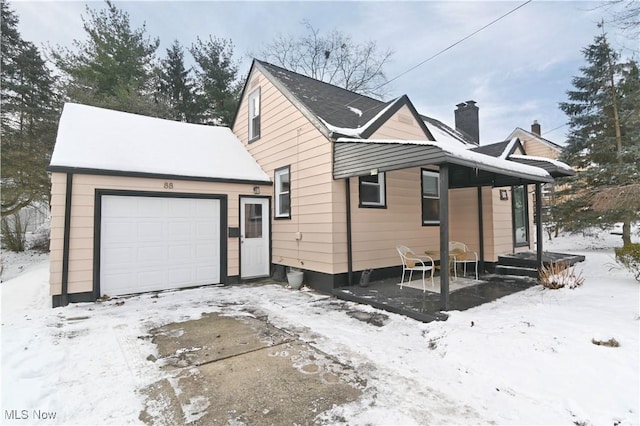 view of snowy exterior featuring a garage