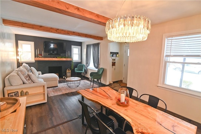 dining space with beam ceiling, dark hardwood / wood-style flooring, an inviting chandelier, and a brick fireplace