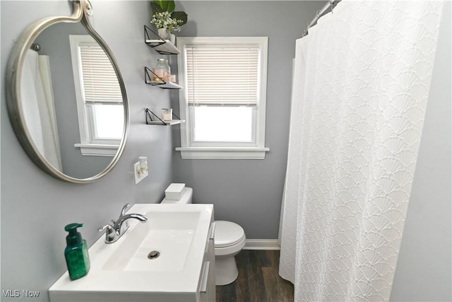 bathroom featuring hardwood / wood-style flooring, toilet, a wealth of natural light, and sink