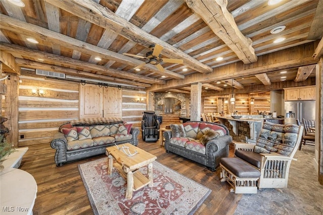 living room featuring wood ceiling, dark wood-type flooring, log walls, beam ceiling, and a barn door