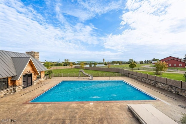 view of swimming pool featuring a patio area, a yard, and a water slide