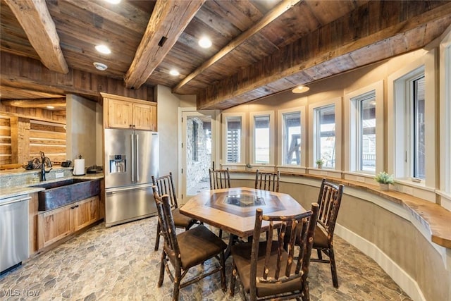 dining area featuring wood walls, sink, beamed ceiling, and wooden ceiling