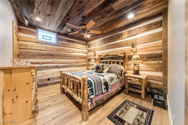 bedroom with ceiling fan, light hardwood / wood-style floors, wooden ceiling, and rustic walls