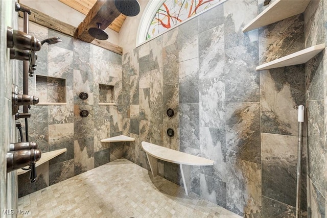 bathroom with vaulted ceiling with beams, a tile shower, and wooden ceiling