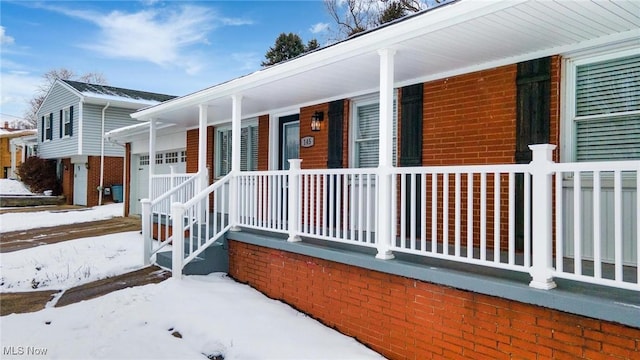 view of snowy exterior featuring covered porch