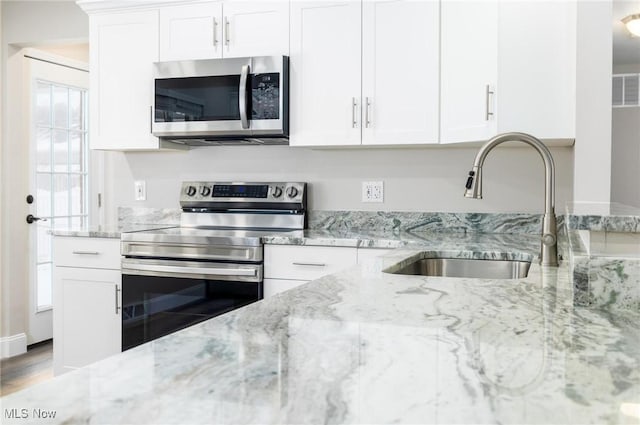 kitchen featuring white cabinetry, sink, and appliances with stainless steel finishes