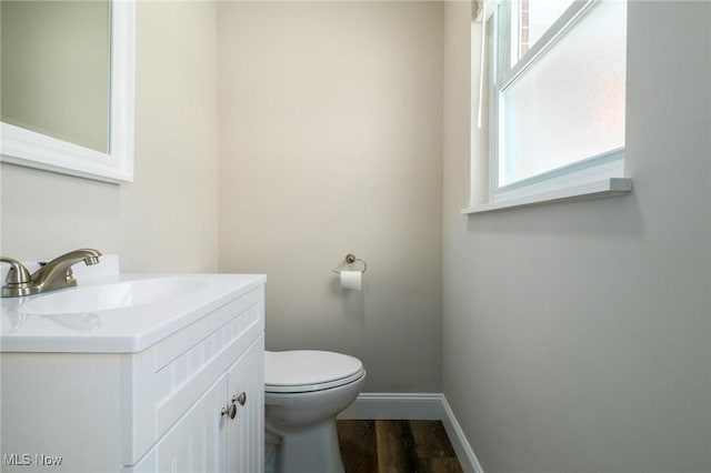 bathroom with hardwood / wood-style flooring, vanity, and toilet