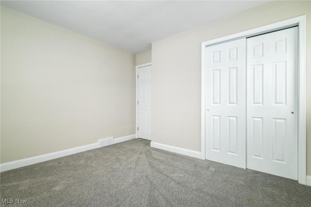 unfurnished bedroom with a closet and carpet floors