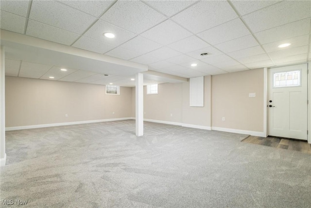 basement featuring a paneled ceiling and carpet floors