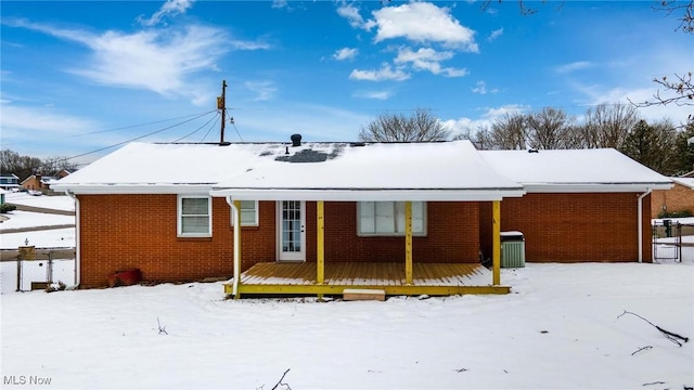 snow covered back of property featuring cooling unit and a deck