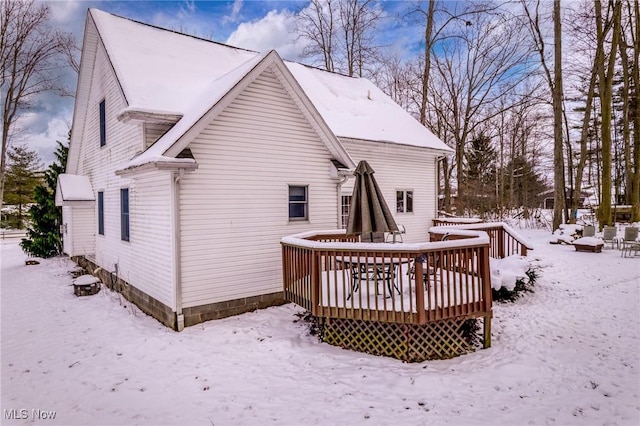 view of snowy exterior with a deck