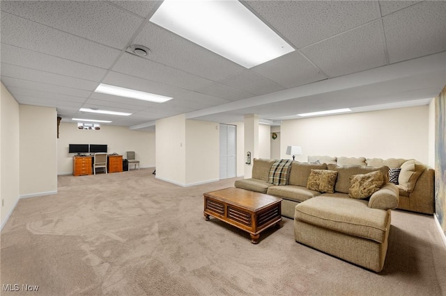 living area featuring a drop ceiling, carpet flooring, and baseboards