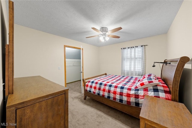 bedroom with light carpet, ceiling fan, a textured ceiling, a walk in closet, and a closet