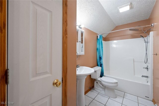 bathroom with tile patterned floors, a textured ceiling, shower / tub combo with curtain, toilet, and lofted ceiling