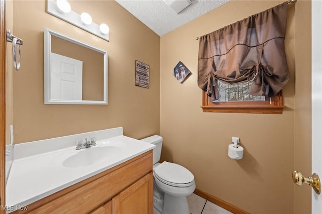 bathroom featuring tile patterned floors, vanity, toilet, and a textured ceiling