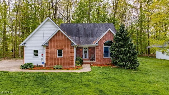 traditional-style house with brick siding, a front lawn, and a shingled roof