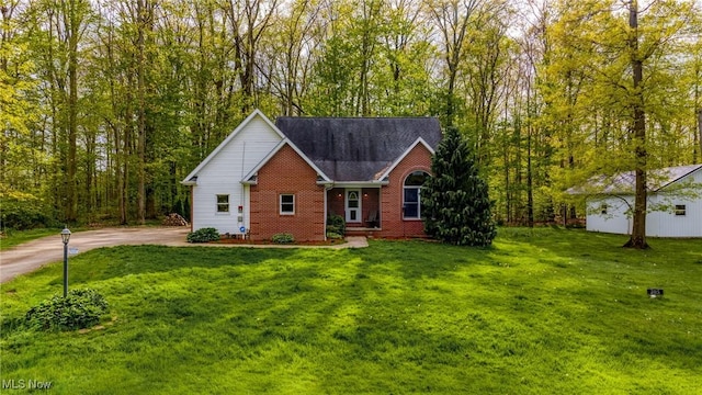 view of front of home featuring brick siding and a front lawn