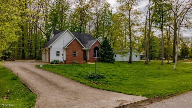 view of front of property with brick siding, driveway, and a front lawn