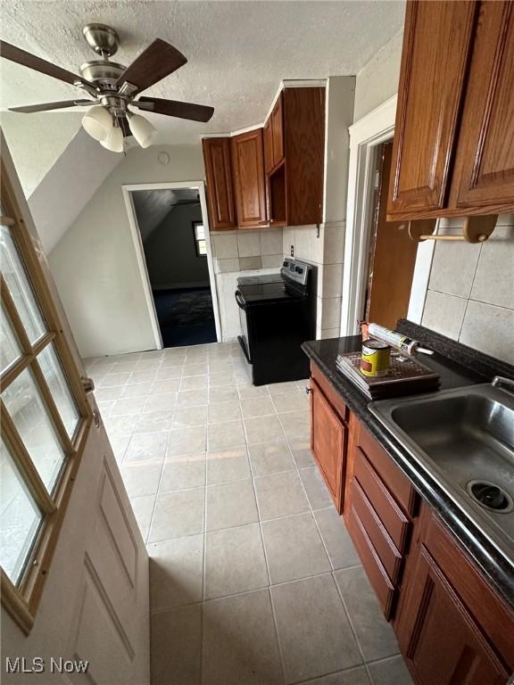 kitchen with ceiling fan, tasteful backsplash, black / electric stove, a textured ceiling, and light tile patterned floors