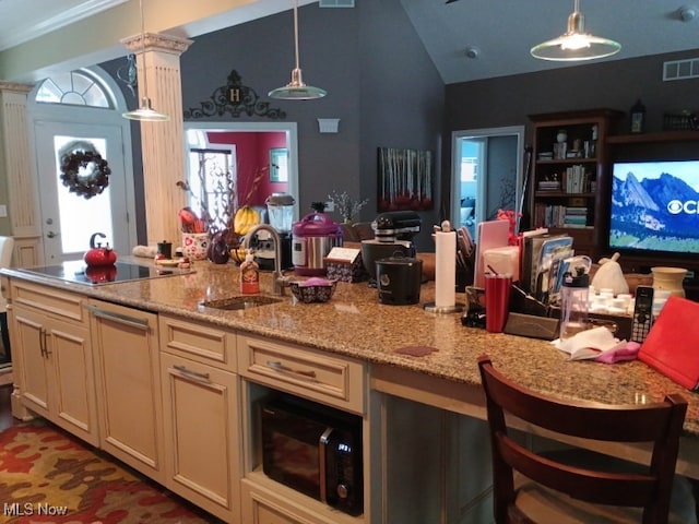 kitchen featuring pendant lighting, lofted ceiling, black appliances, and sink