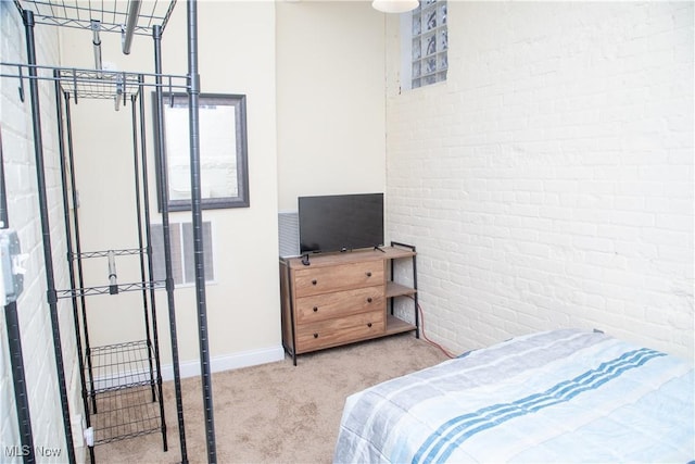 bedroom featuring brick wall and carpet flooring