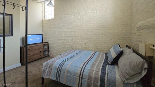 bedroom featuring carpet floors and brick wall