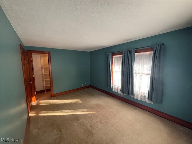 interior space with a textured ceiling and light carpet