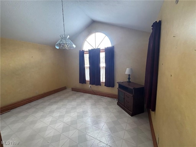 interior space featuring a chandelier, a textured ceiling, and vaulted ceiling