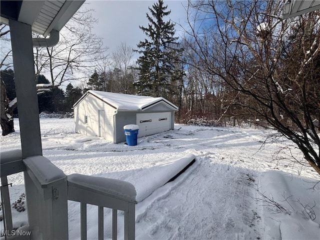 yard covered in snow with an outbuilding and a garage