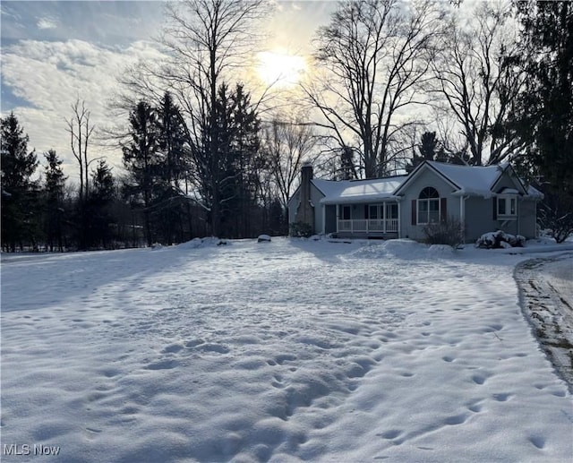 yard layered in snow featuring a porch