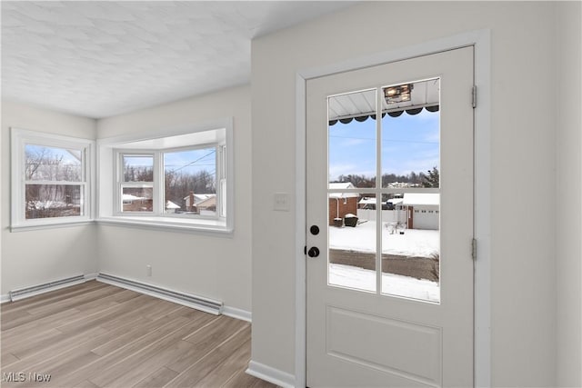 entryway with light hardwood / wood-style flooring and baseboard heating