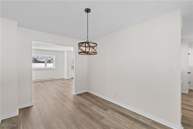 unfurnished dining area featuring wood-type flooring and a chandelier