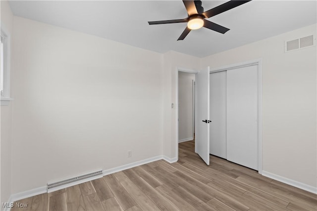 unfurnished bedroom featuring ceiling fan, light hardwood / wood-style floors, and a closet