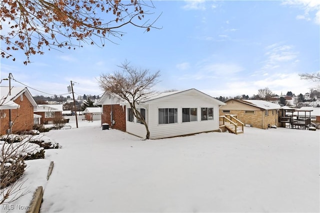 view of snow covered rear of property