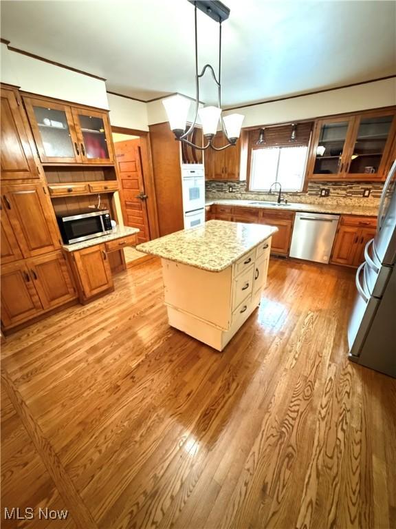 kitchen featuring a center island, hanging light fixtures, light wood-type flooring, and appliances with stainless steel finishes