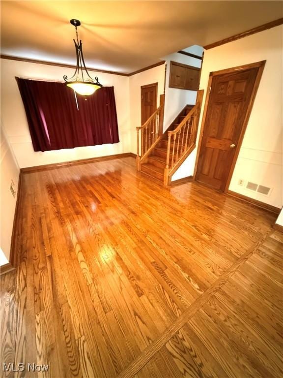 empty room with light hardwood / wood-style floors and ornamental molding