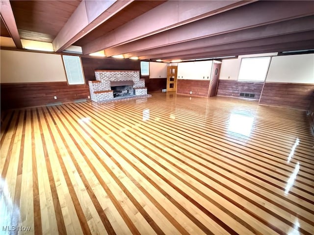 basement with wood walls and a brick fireplace